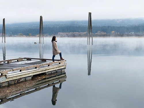 Muejr en el muelle de un lago