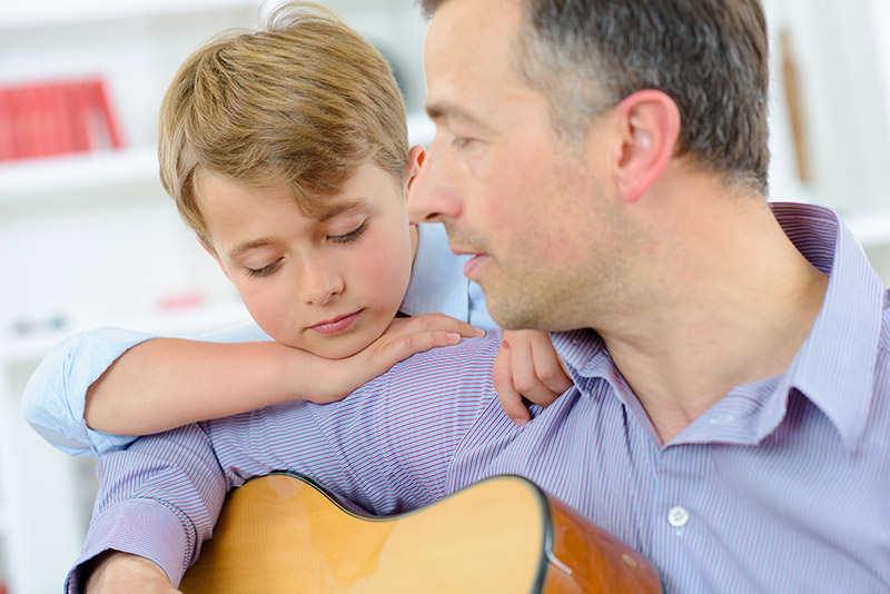 Padre tocando guitarra con hijo